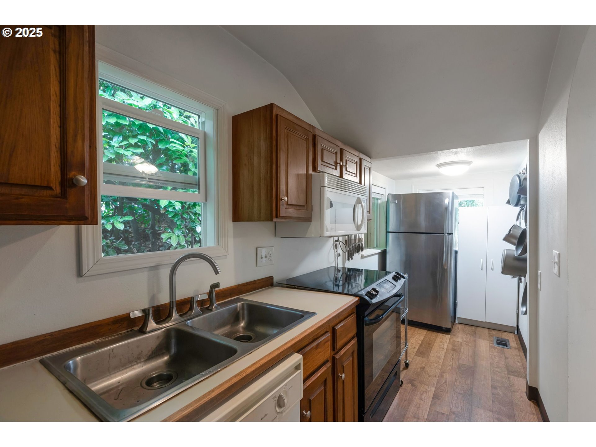 9224 Southwest 26th Avenue Portland, OR 97219 - Photo 18 of 30 a kitchen that has a sink a window and stainless steel appliances
