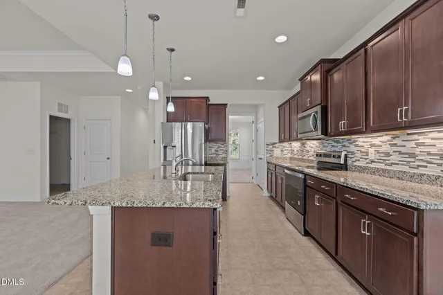 a kitchen with kitchen island a sink stainless steel appliances and cabinets