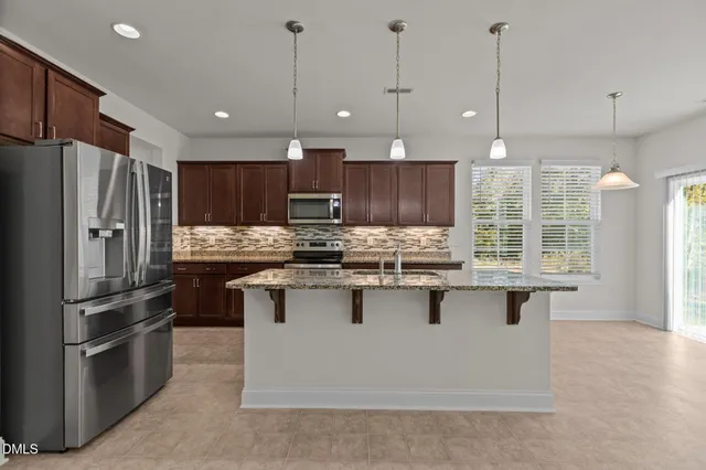 a kitchen with stainless steel appliances granite countertop a stove a sink dishwasher a refrigerator and a microwave oven