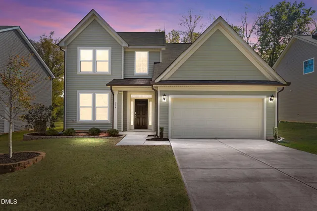a front view of a house with a yard and garage