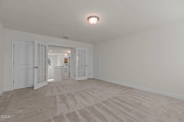 an empty room with chandelier fan