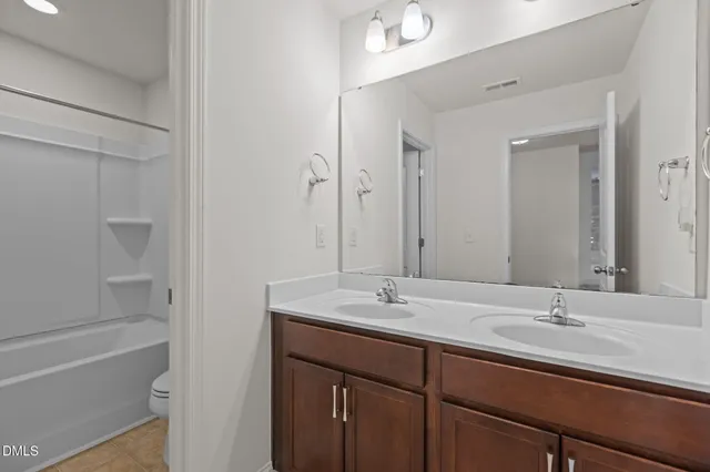 a view of an empty room and chandelier fan