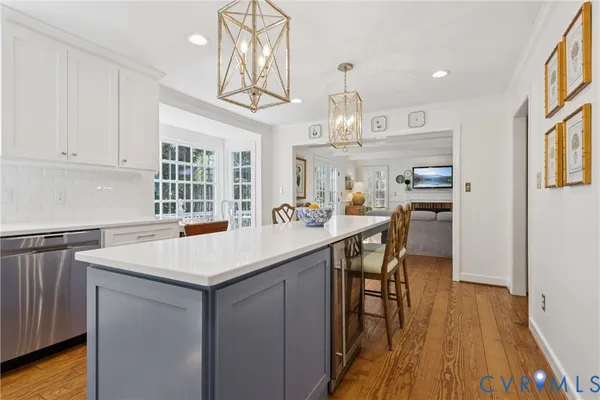 a kitchen with stainless steel appliances a table chairs and wooden floor