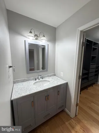 a bathroom with a granite countertop sink and a mirror
