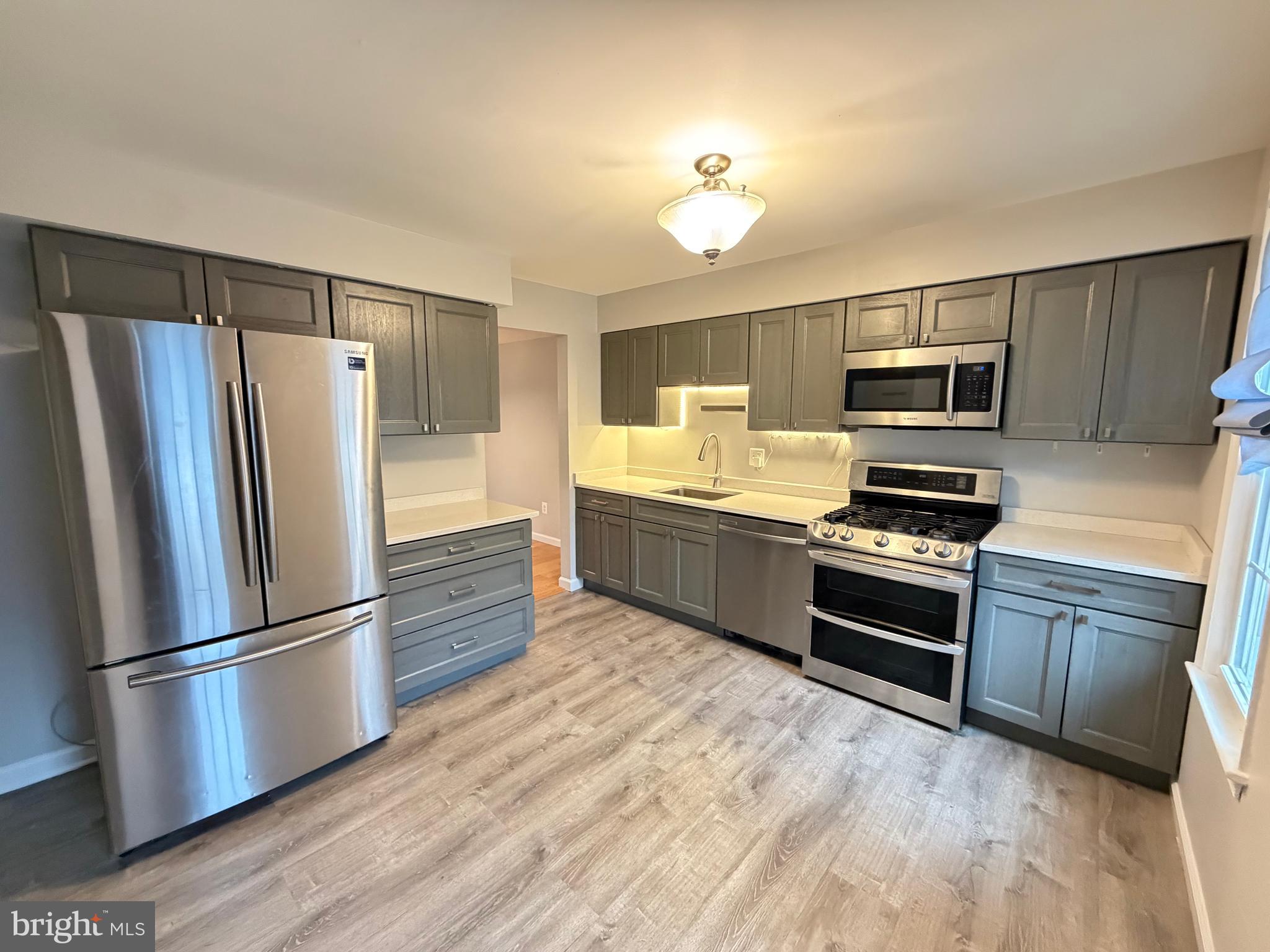 12629 English Orchard Court Silver Spring, MD 20906 - Photo 2 of 31 a kitchen with granite countertop a refrigerator stove and microwave