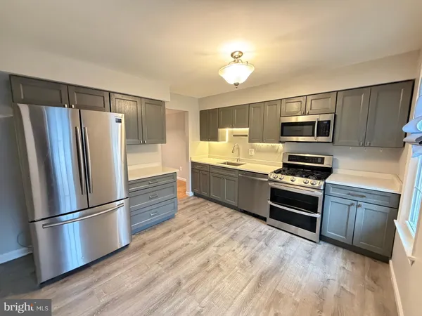 a kitchen with granite countertop a refrigerator stove and microwave