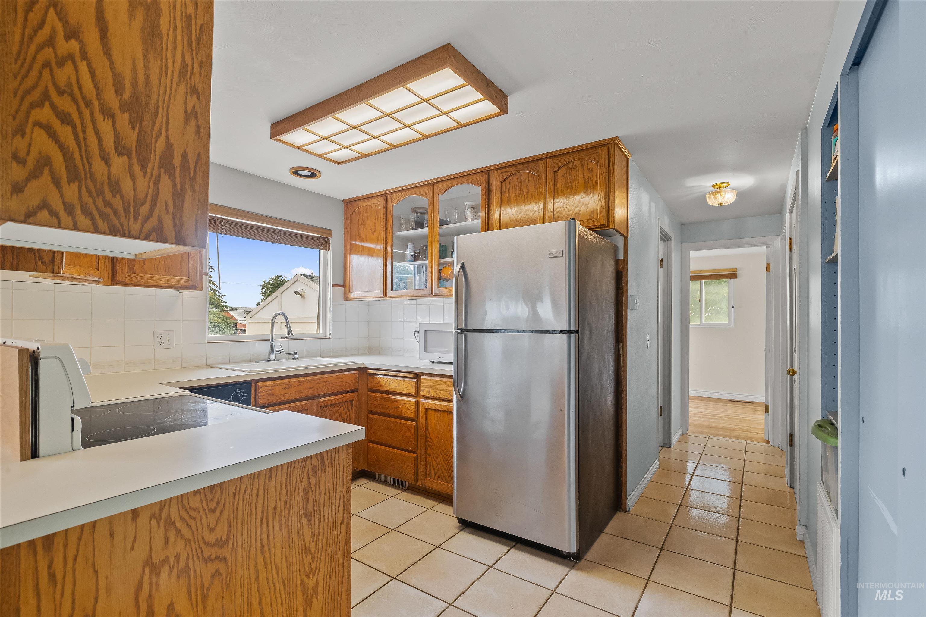 3620 18th Street Lewiston, ID 83501 - Photo 6 of 32 Kitchen featuring wood cabinetry, white countertops, a tiled backsplash, and ceramic tile flooring