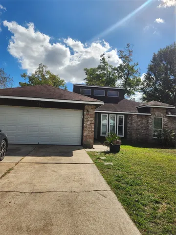a front view of house with yard and trees in the background