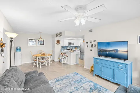 a living room with furniture and a dining table with white walls