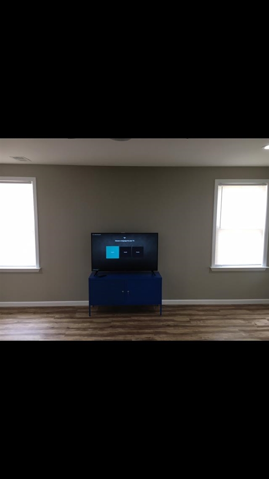 1071 Getwell Road Memphis, TN 38111 - Photo 6 of 6 a view of an empty room with wooden floor and a window