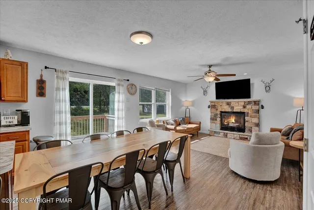 a kitchen with stainless steel appliances granite countertop a stove top oven a sink dishwasher a dining table and chairs with wooden floor