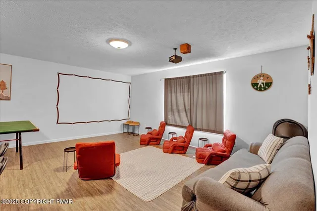 a kitchen with stainless steel appliances granite countertop a stove a refrigerator a sink a dining table and chairs with wooden floor