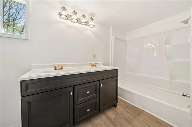a bathroom with a tub sink and mirror