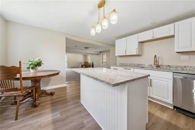 a kitchen with granite countertop a sink a counter space dining table and chairs