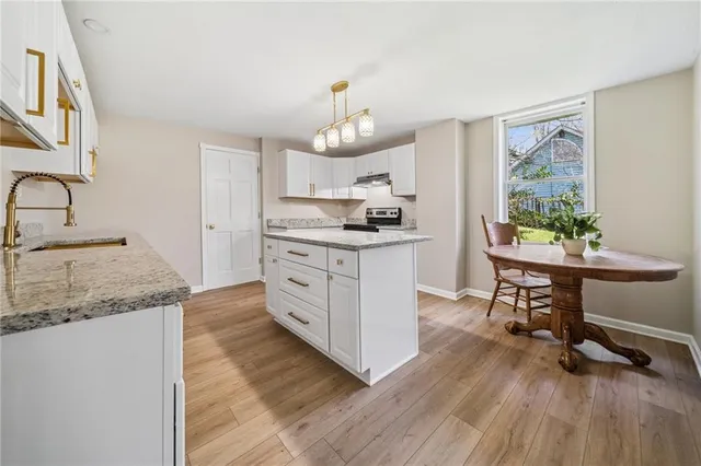 a kitchen with stainless steel appliances granite countertop a stove a sink dishwasher and a refrigerator with wooden floor