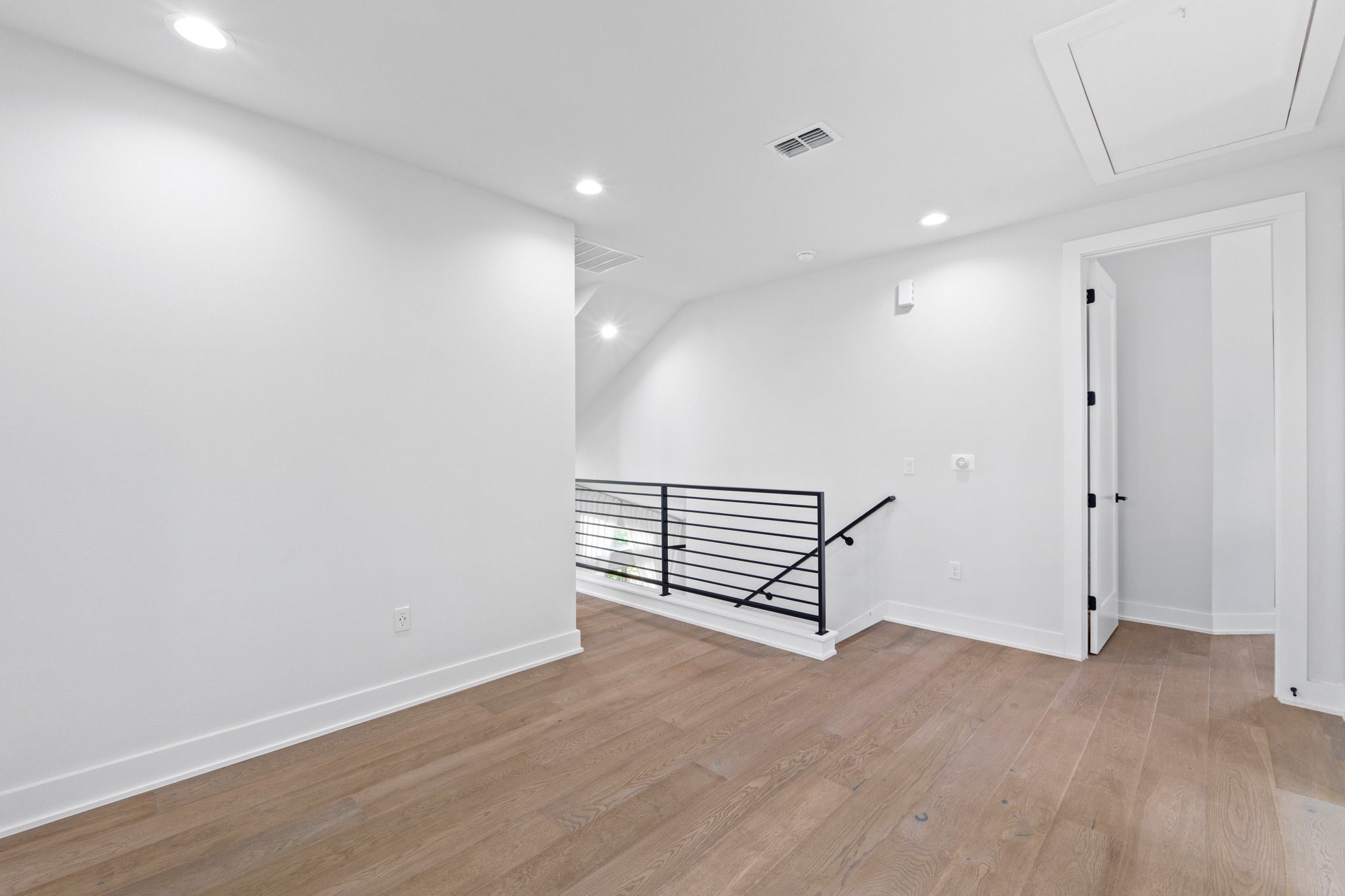 2007 Chestnut Avenue, Unit 1 Austin, TX 78722 - Photo 19 of 32 A lofted hallway with sleek hardwood floors and modern railings, ready for personalization.
