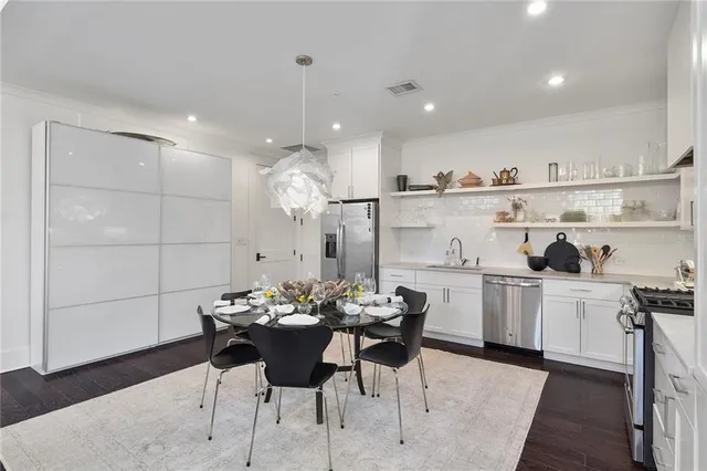 a kitchen with a dining table cabinets and appliances