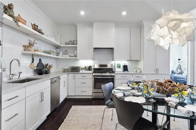 a kitchen with white cabinets stainless steel appliances and stove