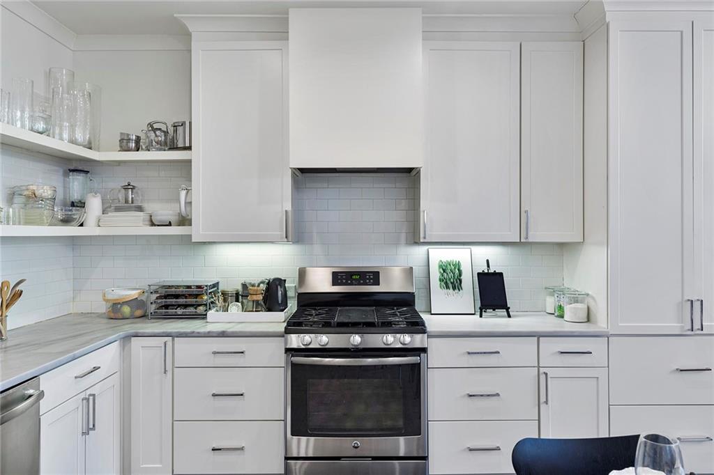 10625 Serenbe Lane, Unit 204 Chattahoochee Hills, GA 30268 - Photo 7 of 20 a kitchen with white cabinets and appliances