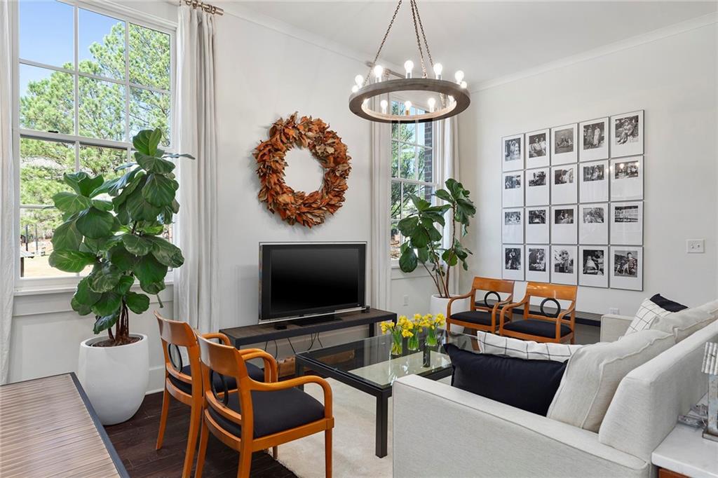 10625 Serenbe Lane, Unit 204 Chattahoochee Hills, GA 30268 - Photo 9 of 20 a living room with furniture a chandelier and a flat screen tv