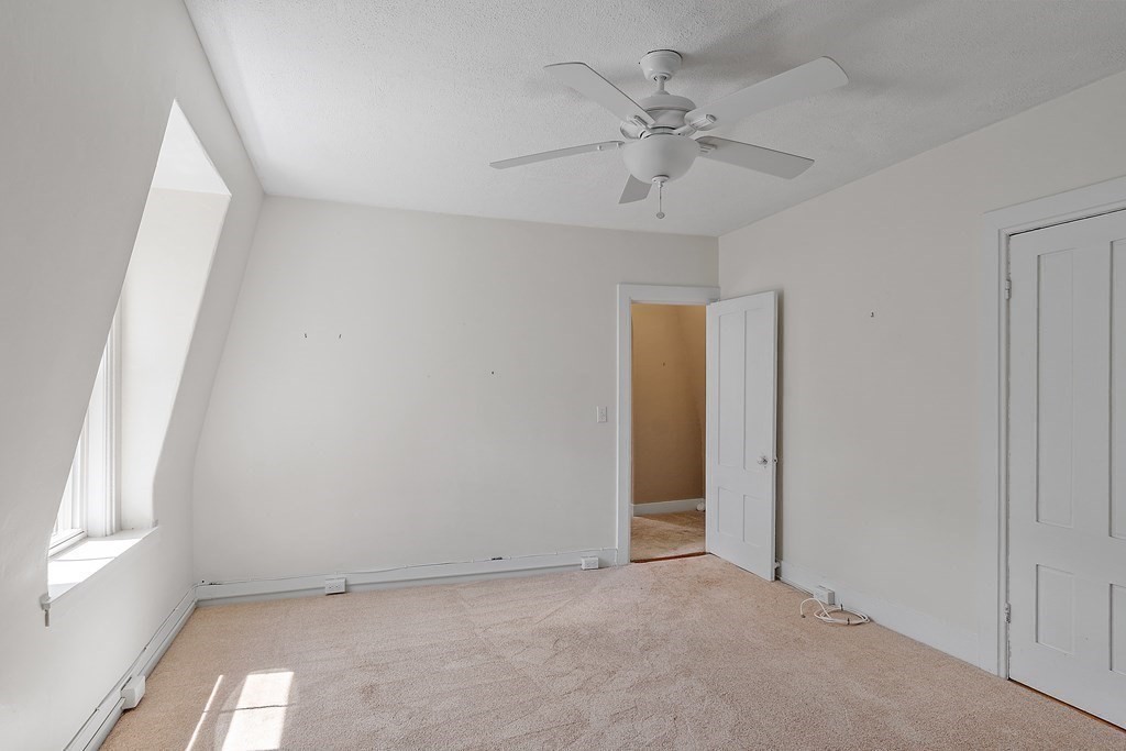 84 A Granite Street, Unit A Rockport, MA 01966 - Photo 14 of 40 an empty room with a ceiling fan and a window