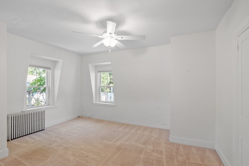 84 A Granite Street, Unit A Rockport, MA 01966 - Photo 15 of 40 an empty room with windows and fan