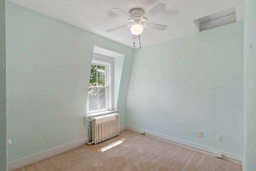 84 A Granite Street, Unit A Rockport, MA 01966 - Photo 18 of 40 an empty room with windows and fan