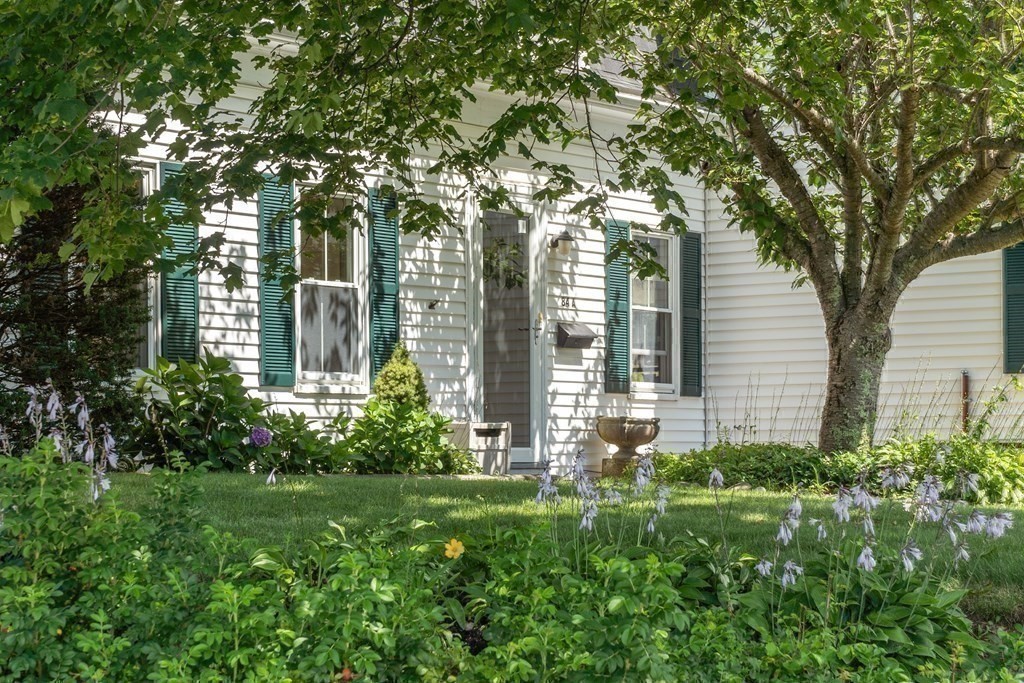 84 A Granite Street, Unit A Rockport, MA 01966 - Photo 34 of 40 a garden with trees in front of it
