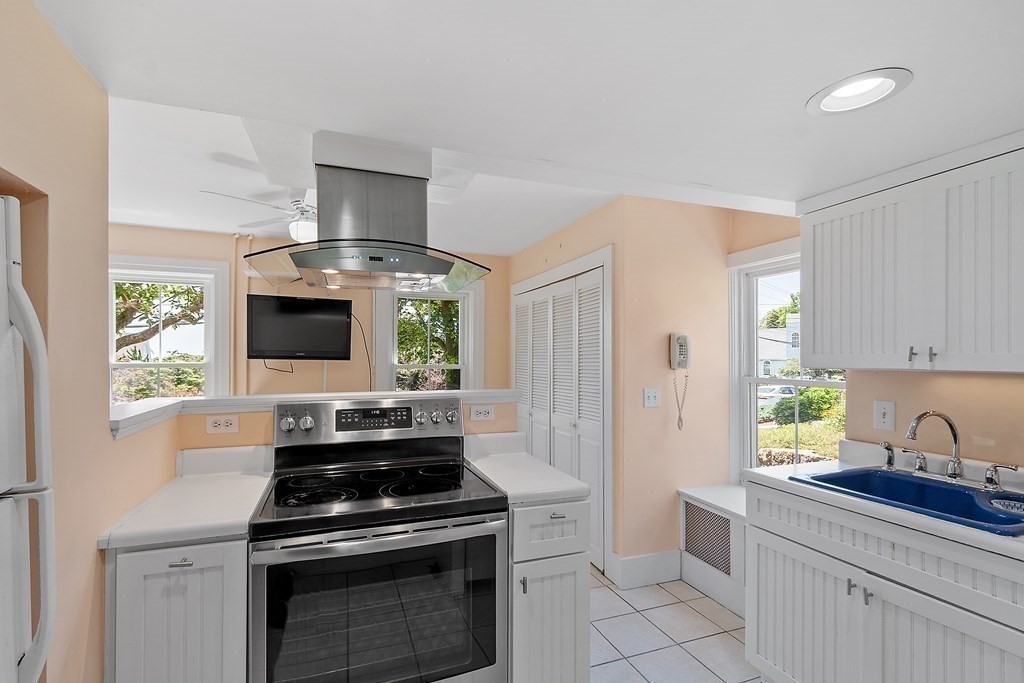 84 A Granite Street, Unit A Rockport, MA 01966 - Photo 7 of 40 a kitchen with stainless steel appliances a stove a sink and a microwave