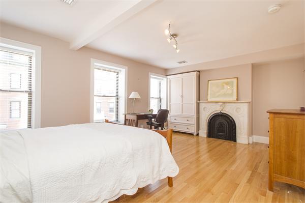 38 Worcester Street, Unit 3 Boston, MA 02118 - Photo 8 of 15 a spacious bedroom with a bed and a fireplace