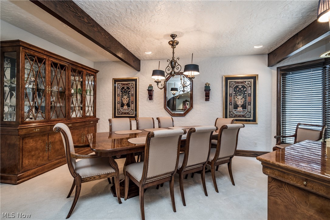 1415 Harbor Drive Northwest Canton, OH 44708 - Photo 8 of 46 Formal Dining room with beamed ceiling, a notable chandelier, a textured ceiling, and light colored carpet