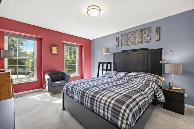 a bedroom with a large bed and a chair