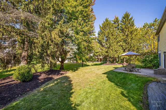 a view of a patio with a table and chairs under an umbrella