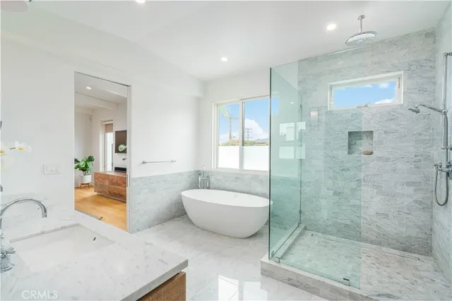 a bathroom with a tub a toilet a sink and mirror