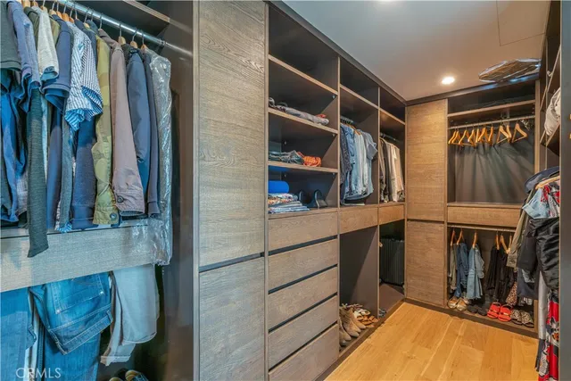 a view of walk in closet with clothes and shoes