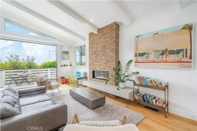 a living room with furniture fireplace and a large window