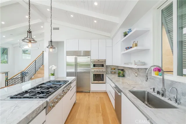 a kitchen with stainless steel appliances granite countertop a sink stove and refrigerator