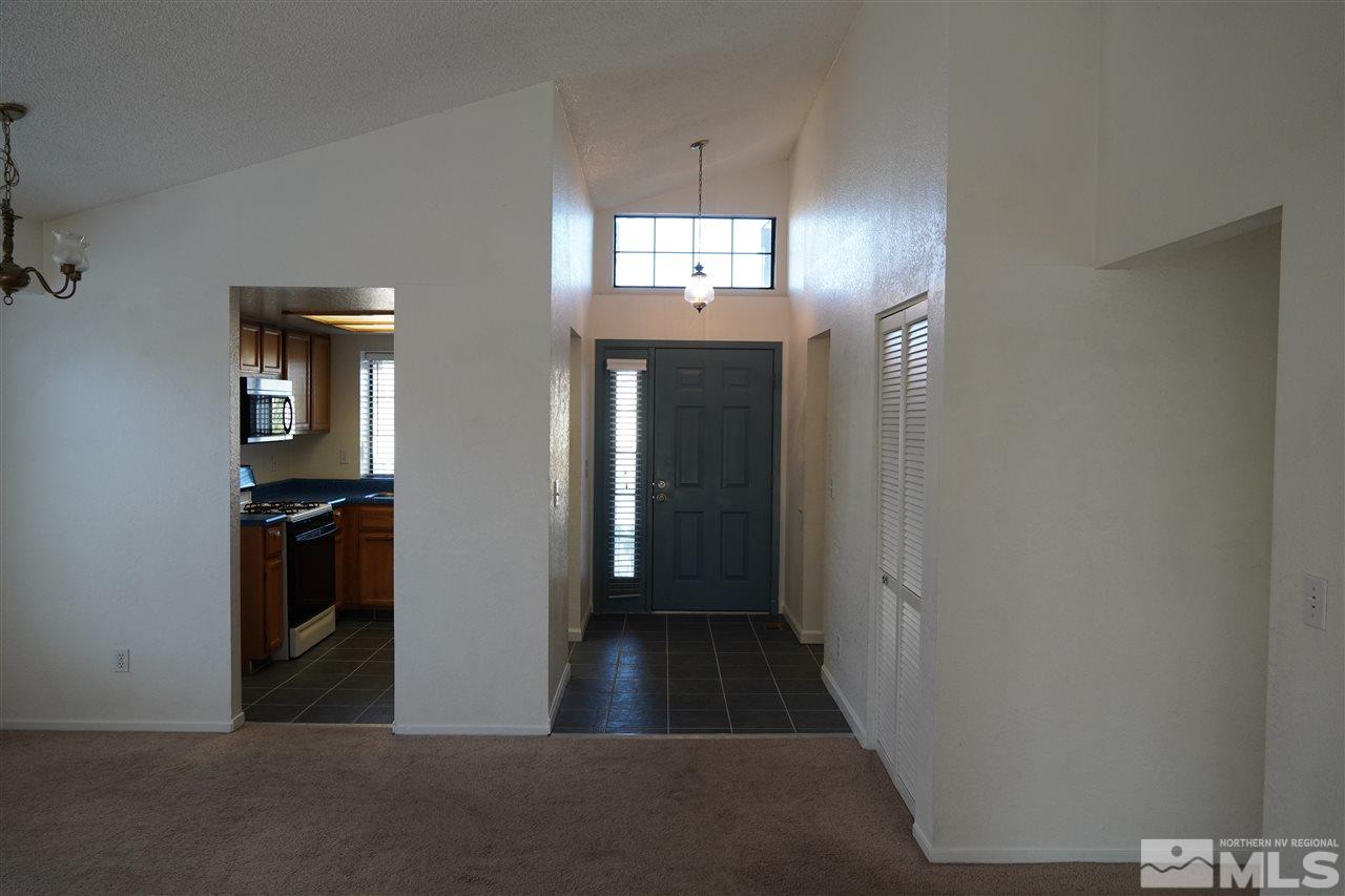 1765 Amarak Way Reno, NV 89523 - Photo 4 of 16 a view of a hallway with wooden floor and a living room