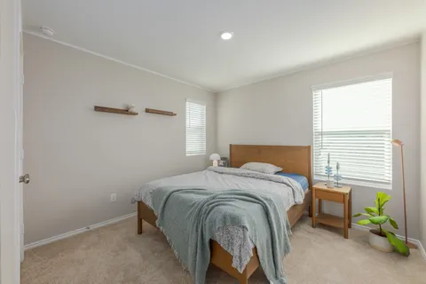a bed sitting in a bedroom next to a window