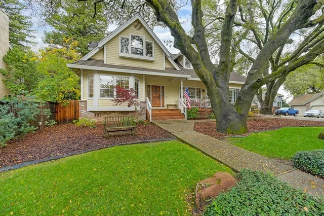 a front view of a house with a garden and trees