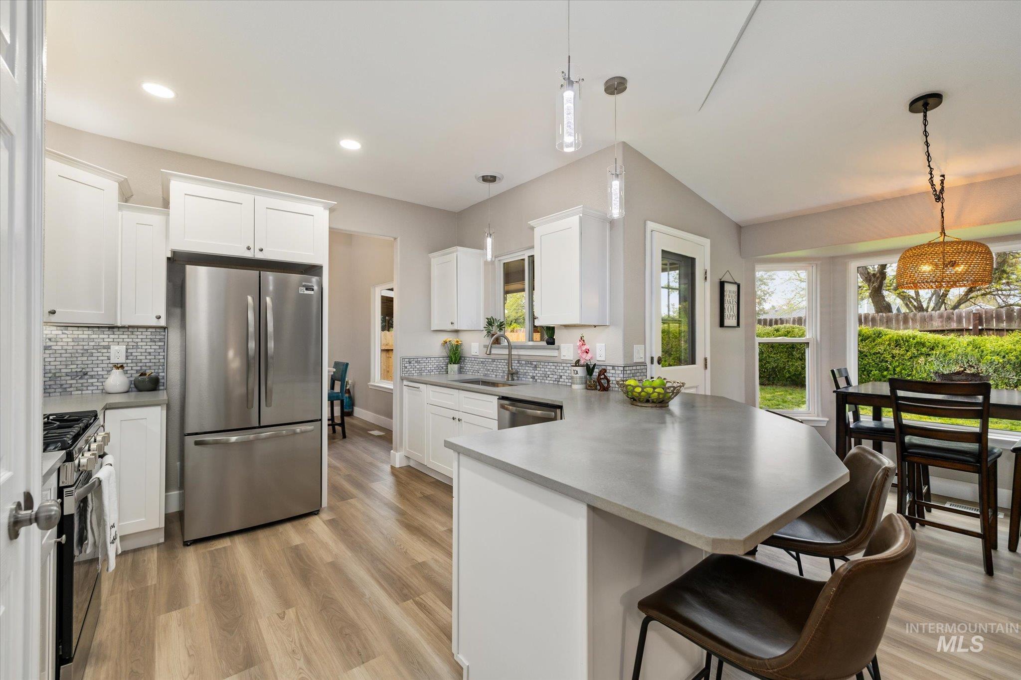 2250 North Amethyst Avenue Meridian, ID 83646 - Photo 20 of 50 Kitchen featuring a peninsula, stainless steel appliances, white cabinetry, a breakfast bar, and hanging light fixtures