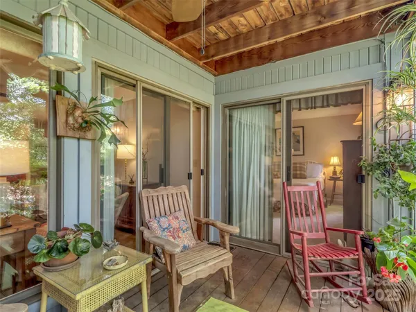 a view of a brick house with a chairs and table in a patio