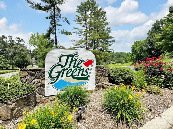 a sign that is sitting in front of flowers