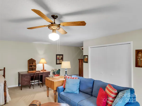 a living room with furniture and a ceiling fan
