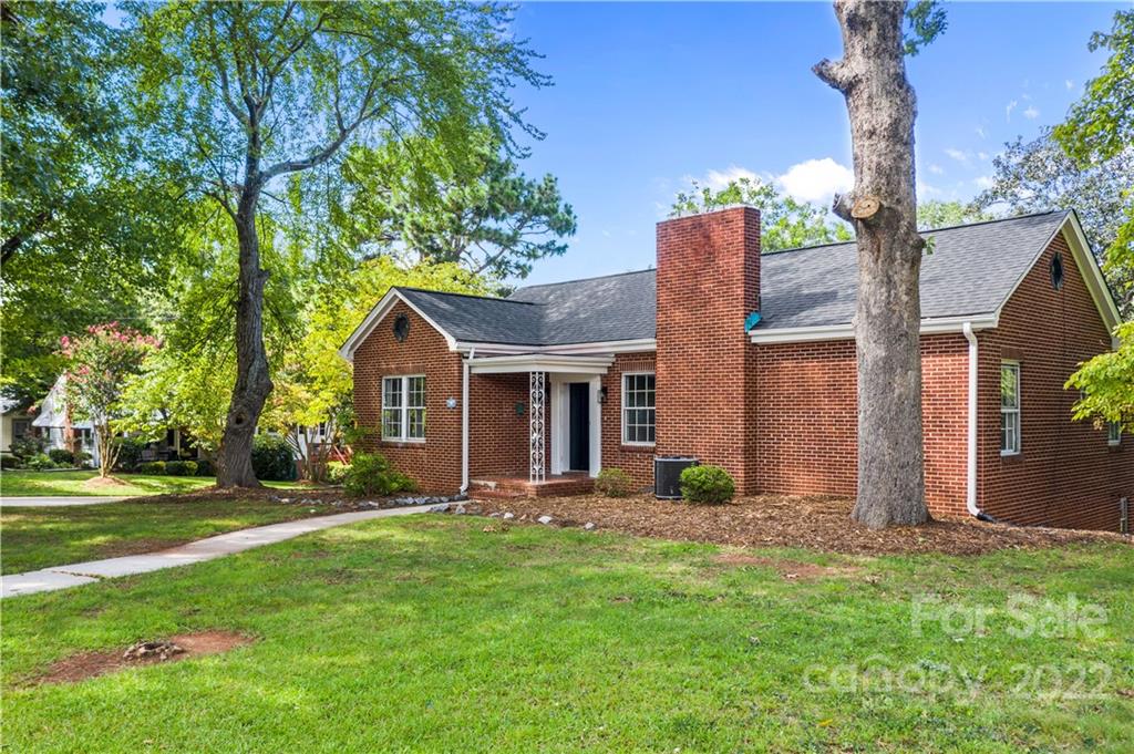 a view of a house with backyard and a tree