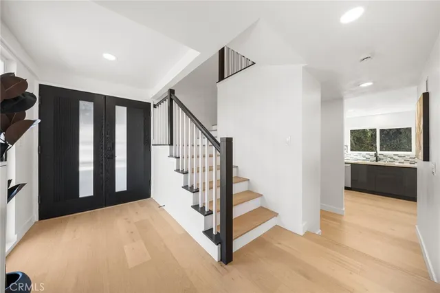 a view of a livingroom with wooden floor and stairs