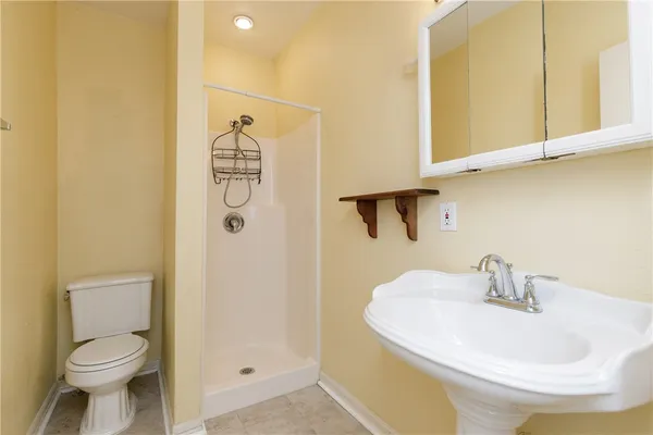 a bathroom with a sink a toilet and shower