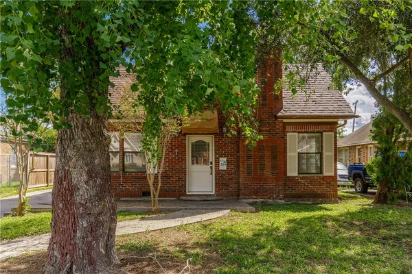 front view of a house with a tree in front of it