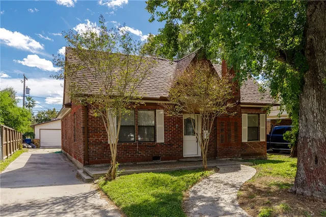 a front view of a house with a garden