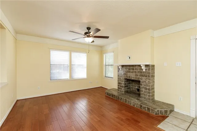 a view of an empty room with a fireplace and a window